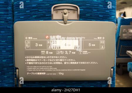 Nahaufnahme des Tabletts auf der Rückseite des blauen bequemen Beifahrersitzes im Shinkansen Nozomi (japanischer Hochgeschwindigkeitszug). Stockfoto