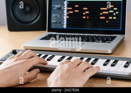 Mann spielt die Midi-Tastatur in einem Heimstudio. Stockfoto