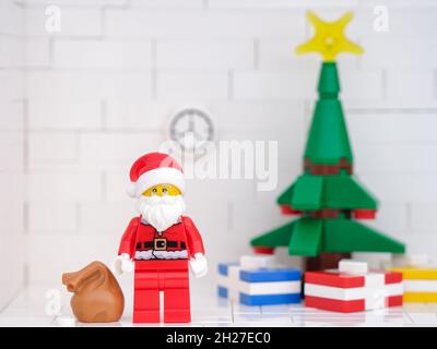 Tambov, Russische Föderation - 17. Oktober 2021 Lego Santa Claus Minifigur in der Nähe eines weihnachtsbaumes, der Geschenke darunter hat. Nahaufnahme. Stockfoto