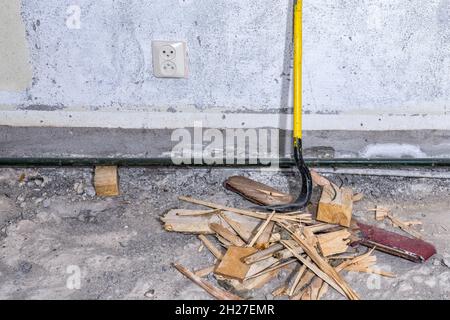 Die Brechstange steht an einer Betonwand auf dem abgerissenen Boden des Zimmers, Nahaufnahme Stockfoto