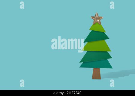 Weihnachtsbaum aus Papier und weihnachtsstern Dekoration. Minimales Urlaubskonzept. Kreatives Winterlayout. Stockfoto