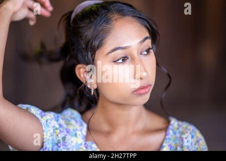 Nahaufnahmen einer jungen multirassischen Frau, die in einem japanischen Gartengebäude sitzt Stockfoto