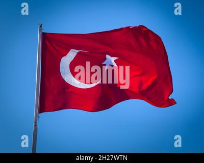 Die rote türkische Flagge fliegt vor dem wolkenlosen Himmel Stockfoto