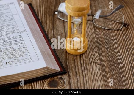 10 OCOBER 2021 New York Time USA: Die Zeit wird knapp mit Sanduhr und offener Bibel, die die Endzeit nach der Heiligen Bibel symbolisiert Stockfoto