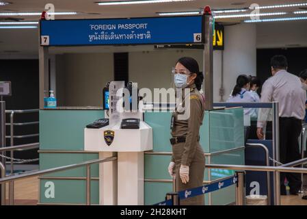 Bangkok, Thailand. Oktober 2021. Ein Einwanderungsbeamter, der eine Gesichtsmaske trägt, als vorbeugende Maßnahme, die während der Coronavirus-Krise am Don Muang International Airport im Einsatz war.Thailands Regierung will das Land am 1. November 2021 wieder eröffnen. Es ermöglicht vollständig geimpften internationalen Touristen aus mindestens zehn risikoarmen Ländern, ohne Quarantäne zu gehen, in das Land einzureisen. Die Wiedereröffnung soll sowohl die Tourismusindustrie als auch die Wirtschaft des Landes fördern. (Foto von Peerapon Boonyakiat/SOPA Images/Sipa USA) Quelle: SIPA USA/Alamy Live News Stockfoto