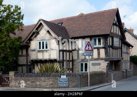 Fachwerkhaus in original unbemalten Farben, mit Straßenschild „überhängendes Gebäude“, Eardisley, Herefordshire Stockfoto