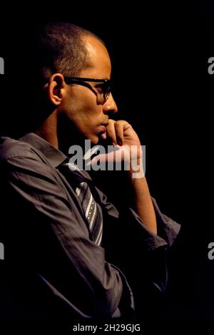 Stehender Schauspieler, der eine Figur in einem Theater darstellt. Schwarzer Hintergrund in der Szene. Salvador Bahia Brasilien. Stockfoto