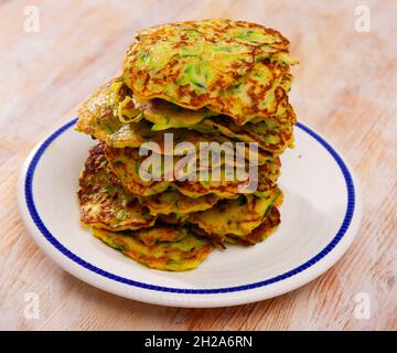 Zucchini-Krapfen auf dem Teller Stockfoto