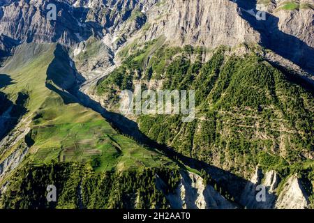 Landschaft aus grünen Feldern und Wäldern an den steilen Hängen eines Himalaya-Berges Stockfoto