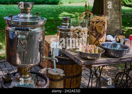 Rustikale Teeparty mit Samowar, Keksen und Marmelade im Park Stockfoto