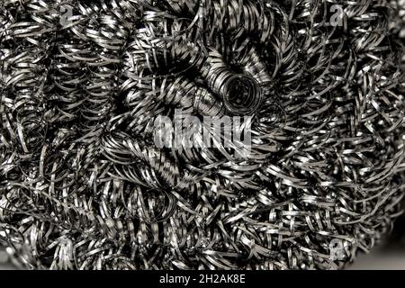 Scheuerschwämme aus Stahlwolle oder Scheuerschwämme aus Edelstahlwolle, Nahaufnahme. Küche Reinigung Hintergrund Textur. Metallwickelstruktur mit Spiralspirale Stockfoto