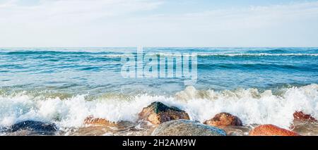 Wellen des blauen Meeres, die gegen die Küstenfelsen krachen, Horizont-Linie im Meer Stockfoto