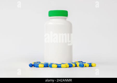 Nahaufnahme Gruppe von gelben und blauen Kapsel Medizin mit Plastikflasche auf weißem Hintergrund. Stockfoto