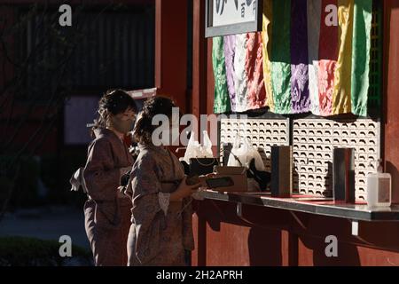 Tokio, Japan. Oktober 2021. Frauen, die in Kimono gekleidet waren, sahen, wie sie im Senso-Ji-Tempel in Asakusa, Tokio, „Mikuji“ (Glücksscheine) kauften.Nachdem am 30. September der mit der Covid-19-Pandemie verbundene Ausnahmezustand aufgehoben wurde, kehren Besucher zu Tokyos touristischem Hotspot in Asakusa zurück. Kredit: SOPA Images Limited/Alamy Live Nachrichten Stockfoto