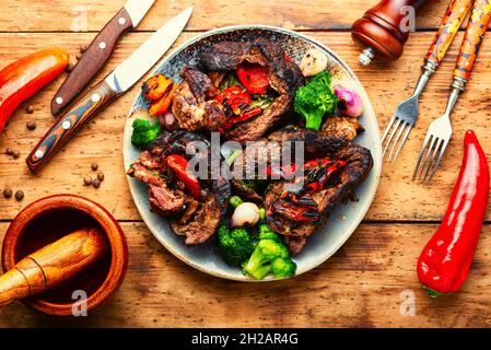 Mit Gemüse gefüllte Rinderrolle. Hackbraten auf altem Holzhintergrund Stockfoto
