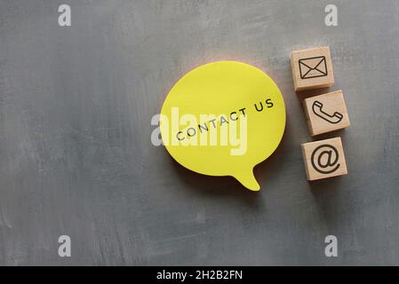Business, kontaktieren Sie uns Konzept. Sprechblase mit TEXTKONTAKT und Holzblöcken mit Adresse, Telefon und E-Mail-Symbol. Stockfoto