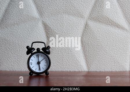 Schwarzer Wecker auf dem Tisch mit Platz für Text Stockfoto