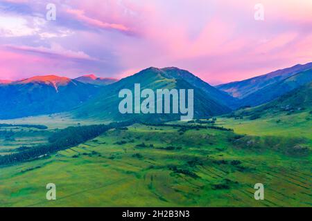 Berg- und Waldlandschaft mit Grünland-Naturlandschaft bei Sonnenaufgang im Dorf Hemu, Xinjiang, China. Stockfoto