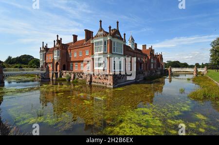 Helmingham Hall mit Graben Brücken und Reflexionen. Stockfoto