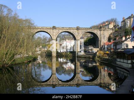 Eisenbahnviadukt und Spiegelungen im Fluss Nidd kurz nach Sonnenaufgang in Knaresborough, North Yorkshire, England Stockfoto