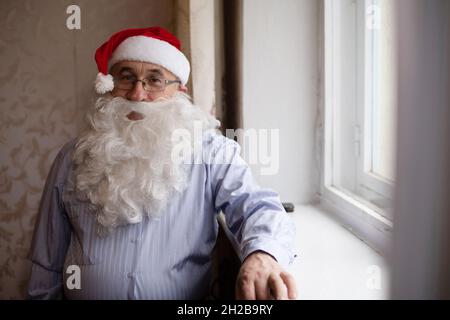 Porträt eines älteren Mannes in santa hat, der die Kamera anschaut Stockfoto