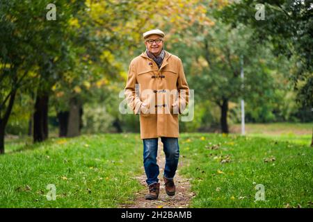 Happy Senior läuft im Herbst im Park. Stockfoto