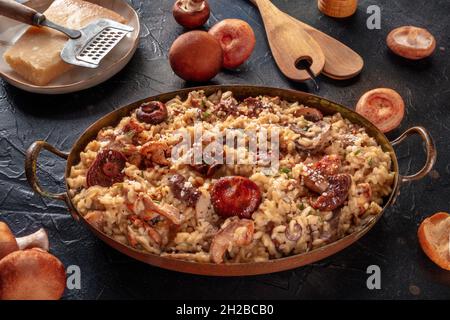 Risotto ai funghi, Pilzreis, mit Zutaten, auf schwarzem Hintergrund Stockfoto