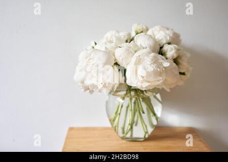 Weiße Pfingstrosen in einer Glasvase. Schöne Pfingstrose Blume für Katalog oder Online-Shop. Blumengeschäft Konzept . Schönes, frisch geschnittenes Bouquet. Lieferung von Blumen Stockfoto
