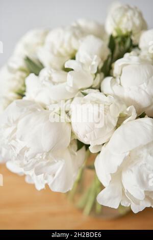 Weiße Pfingstrosen in einer Glasvase. Schöne Pfingstrose Blume für Katalog oder Online-Shop. Blumengeschäft Konzept . Schönes, frisch geschnittenes Bouquet. Lieferung von Blumen Stockfoto