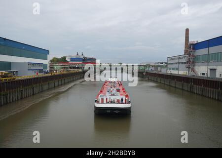 Hamburg, Deutschland. Oktober 2021. Eine Barge fährt zum Werksgelände der Aurubis AG. Die größte Kupferhütte Europas, Aurubis, hat in Hamburg eine 85 Millionen Euro teure Anlage zur Reduzierung der Feinstaubemissionen in Betrieb genommen. Das Abluftsystem mit ultrafeinen Filtern und modernster Anlagentechnik reduziert die so genannten diffusen Staubemissionen um bis zu 70 Prozent. Kredit: Marcus Brandt/dpa/Alamy Live Nachrichten Stockfoto