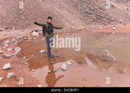 Junger Mann in den Bergen, genießt die frische Luft und die schöne Aussicht. Stockfoto