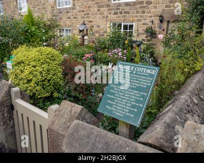 Information Board vor einem bunten Bauerngarten im Sommer in einem der so genannten Pest Cottages, Eyam, Derbyshire, Großbritannien Stockfoto