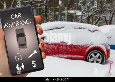 Frau Hand hält Smartphone, um Kfz-Versicherung Anwendung online nach seinem kaputten Auto zu verwenden. Versicherungskonzept. Stockfoto