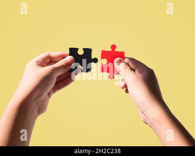 Hände halten schwarz und rot Farbe Stichsägen isoliert auf schönen Pastellfarben Hintergrund. Stockfoto