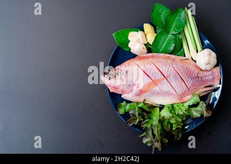 Blick von oben auf frischen Fisch und Gemüse in keramischen Gerichten, die zum Kochen mit Kopierfläche zubereitet werden. Stockfoto