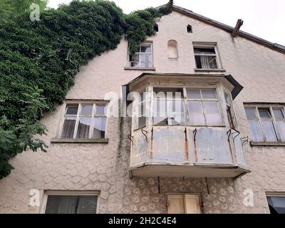 Englischer Efeu, gemeiner Efeu (Hedera Helix), der an einer Fassade eines alten Hauses klettert, Deutschland, Bayern Stockfoto