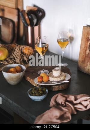 Orangenwein in Gläsern, Obst und Käse auf Holzbrett Stockfoto