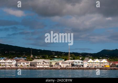 Hell gestrichene Häuser am Hafen von Charlestown. Charlestown, Nevis Island, West Indies. Stockfoto