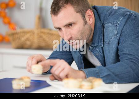 Mann, der Tapas für seine Freunde zubereitete Stockfoto