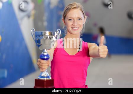 Wunderschöne blonde junge Frau mit einer großen Trophäe Stockfoto