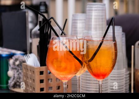 Tassen mit orangefarbenem alkoholischen Cocktail mit Eis auf der Theke - Nahaufnahme Stockfoto