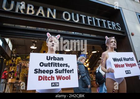 London, Großbritannien. Oktober 2021. Als blutige Schafe gekleidete PETA-Anhänger protestieren vor einer Niederlassung von Urban Outfitters in der Oxford Street, um ein Ende des Wollverkaufs zu fordern. Der Protest ist Teil einer internationalen PETA-Kampagne, die Marken wie Anthropologie und Free People von Urban Outfitters Inc dazu auffordert, den Verkauf von Materialien, die grausam von Tieren genommen wurden, einzustellen. Kredit: Mark Kerrison/Alamy Live Nachrichten Stockfoto