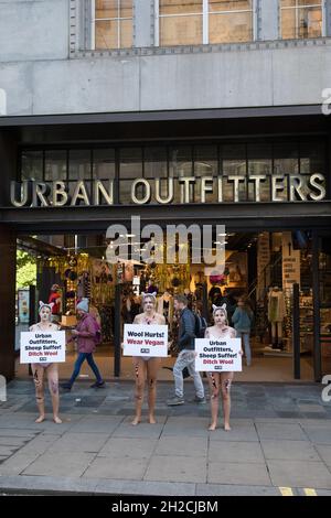 London, Großbritannien. Oktober 2021. Als blutige Schafe gekleidete PETA-Anhänger protestieren vor einer Niederlassung von Urban Outfitters in der Oxford Street, um ein Ende des Wollverkaufs zu fordern. Der Protest ist Teil einer internationalen PETA-Kampagne, die Marken wie Anthropologie und Free People von Urban Outfitters Inc dazu auffordert, den Verkauf von Materialien, die grausam von Tieren genommen wurden, einzustellen. Kredit: Mark Kerrison/Alamy Live Nachrichten Stockfoto