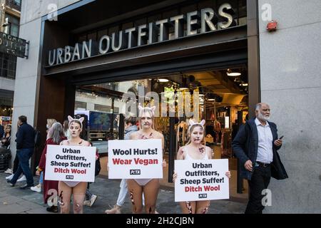 London, Großbritannien. Oktober 2021. Als blutige Schafe gekleidete PETA-Anhänger protestieren vor einer Niederlassung von Urban Outfitters in der Oxford Street, um ein Ende des Wollverkaufs zu fordern. Der Protest ist Teil einer internationalen PETA-Kampagne, die Marken wie Anthropologie und Free People von Urban Outfitters Inc dazu auffordert, den Verkauf von Materialien, die grausam von Tieren genommen wurden, einzustellen. Kredit: Mark Kerrison/Alamy Live Nachrichten Stockfoto