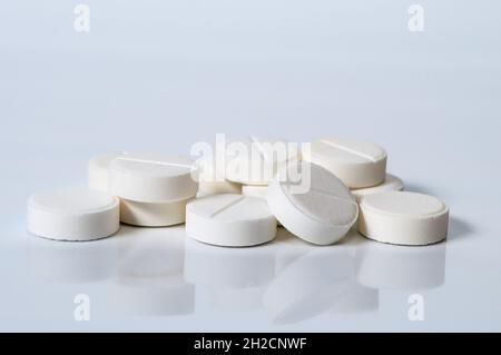 Weiße Tabletts auf weißem Hintergrund. Pharmakologisches Konzept Stockfoto