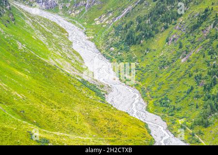 Enger gedrehter felsiger Bach im alpinen Tal Stockfoto