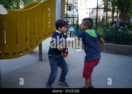 Jungs kämpfen auf dem Spielplatz, Paris, Frankreich Stockfoto