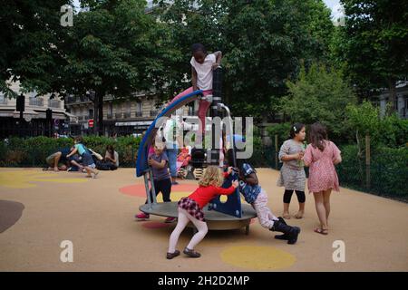 Kinder unterschiedlichen Alters und ethnischer Herkunft spielen zusammen auf dem Spielplatz, Square d'Anvers, 75009 Paris, Frankreich Stockfoto