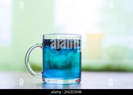 Eine transparente Tasse Butterfly Blue Erbsentee aus Glas. Stockfoto