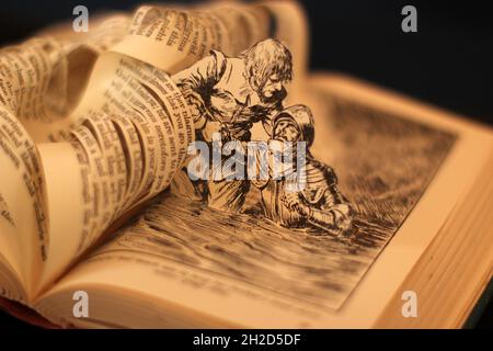 Buchskulptur aus dem Fortschritt des Pilgrim von John Bunyan, der seinen Bruder hoffnungsvoll vor ertrinkender Papierkunst rettet. Mit verschwommenem Bokeh-Hintergrund. Stockfoto